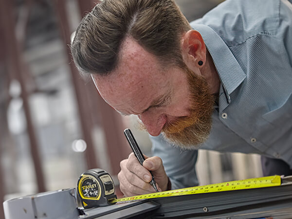 Man carefully measuring a window